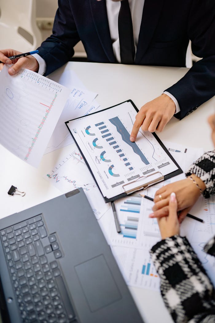 Teamwork in a modern office setting with charts and laptops showcasing collaboration.